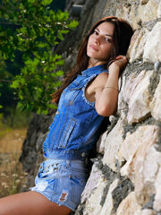 First timer Aleksandrina poses in front of the stone wall having fun with her amazing curves