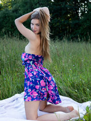 Lara Sugar reveals her ornate dress on the grass as she shows off her young body