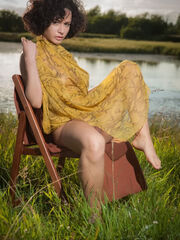Pammie Lee delightfully poses among the grass-covered field as she cares her stacked body and unshaven beaver